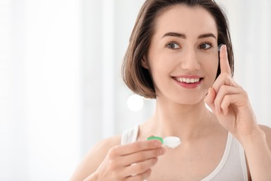 Photo of Woman with contact lens and case indoors. Space for text