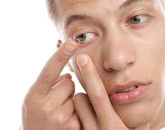 Photo of Man putting in contact lens on white background, closeup