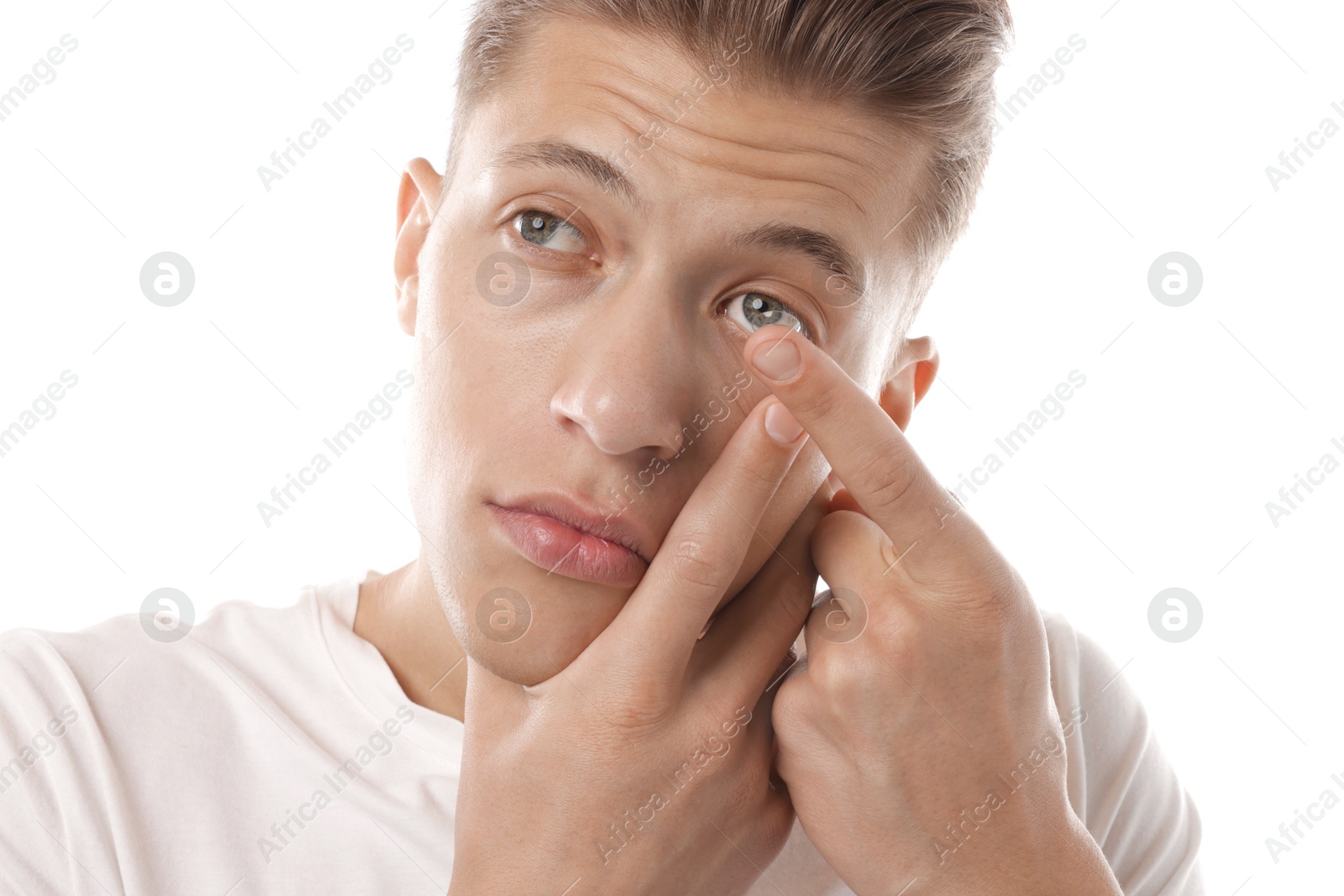 Man putting in contact lens on white background Photo of Man putting in contact lens on white background