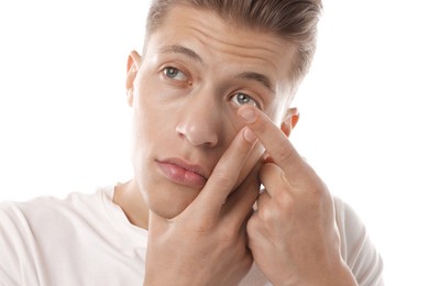 Photo of Man putting in contact lens on white background
