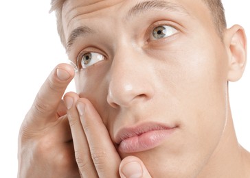 Photo of Man putting in contact lens on white background, closeup