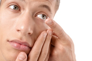 Photo of Man putting in contact lens on white background, closeup