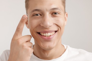 Photo of Man with contact lens on light background, closeup