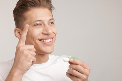 Photo of Man with contact lens and case on light background. Space for text