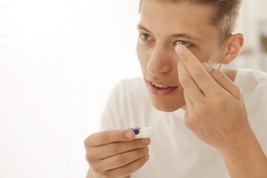Photo of Man putting in contact lens at home, closeup. Space for text