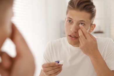 Photo of Man putting in contact lens at home