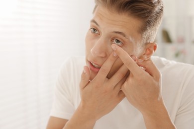 Photo of Man putting in contact lens at home
