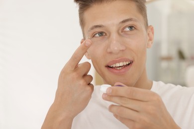 Photo of Man putting in contact lens at home