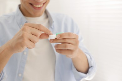 Photo of Man with case of contact lenses at home, closeup
