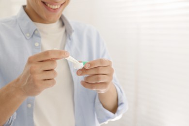 Photo of Man taking contact lens out of case at home, closeup. Space for text