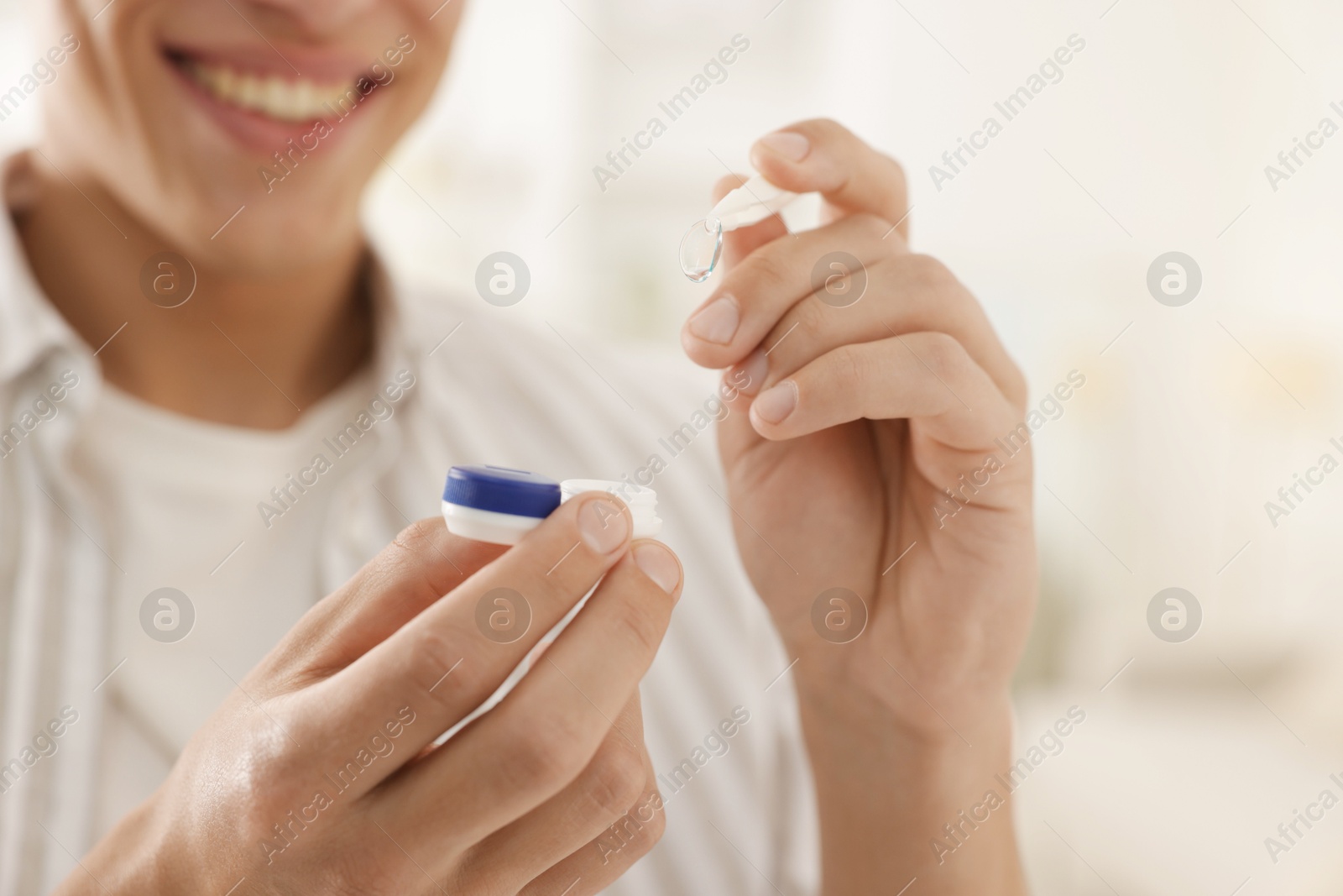 Man taking contact lens out of case at home, closeup Photo of Man taking contact lens out of case at home, closeup