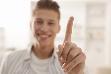 Photo of Man with contact lens at home, selective focus
