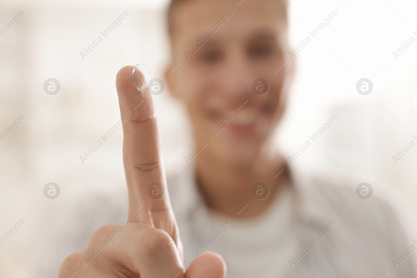Man with contact lens at home, selective focus Photo of Man with contact lens at home, selective focus