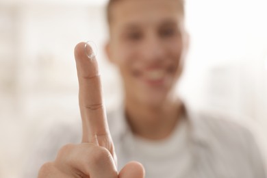 Photo of Man with contact lens at home, selective focus