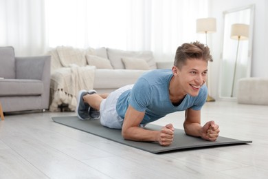 Photo of Man doing plank exercise at home. Sport and healthy lifestyle