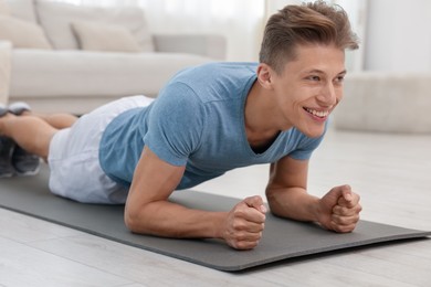 Photo of Man doing plank exercise at home. Sport and healthy lifestyle