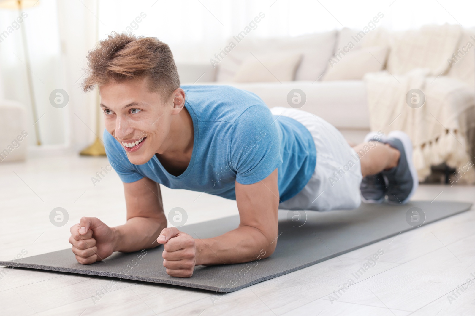 Man doing plank exercise at home. Sport and healthy lifestyle Photo of Man doing plank exercise at home. Sport and healthy lifestyle