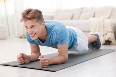 Photo of Man doing plank exercise at home. Sport and healthy lifestyle