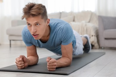Photo of Man doing plank exercise at home. Sport and healthy lifestyle