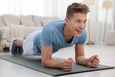 Photo of Man doing plank exercise at home. Sport and healthy lifestyle