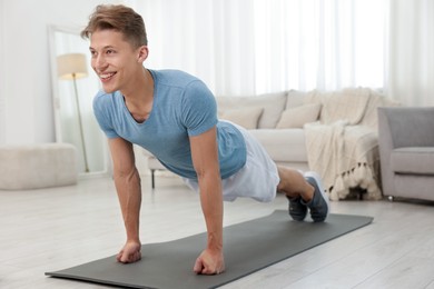 Photo of Man doing plank exercise at home. Sport and healthy lifestyle