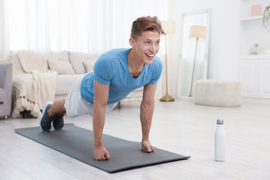 Photo of Man doing plank exercise at home. Sport and healthy lifestyle