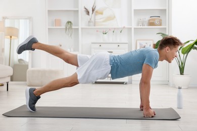 Photo of Man doing plank exercise at home. Sport and healthy lifestyle
