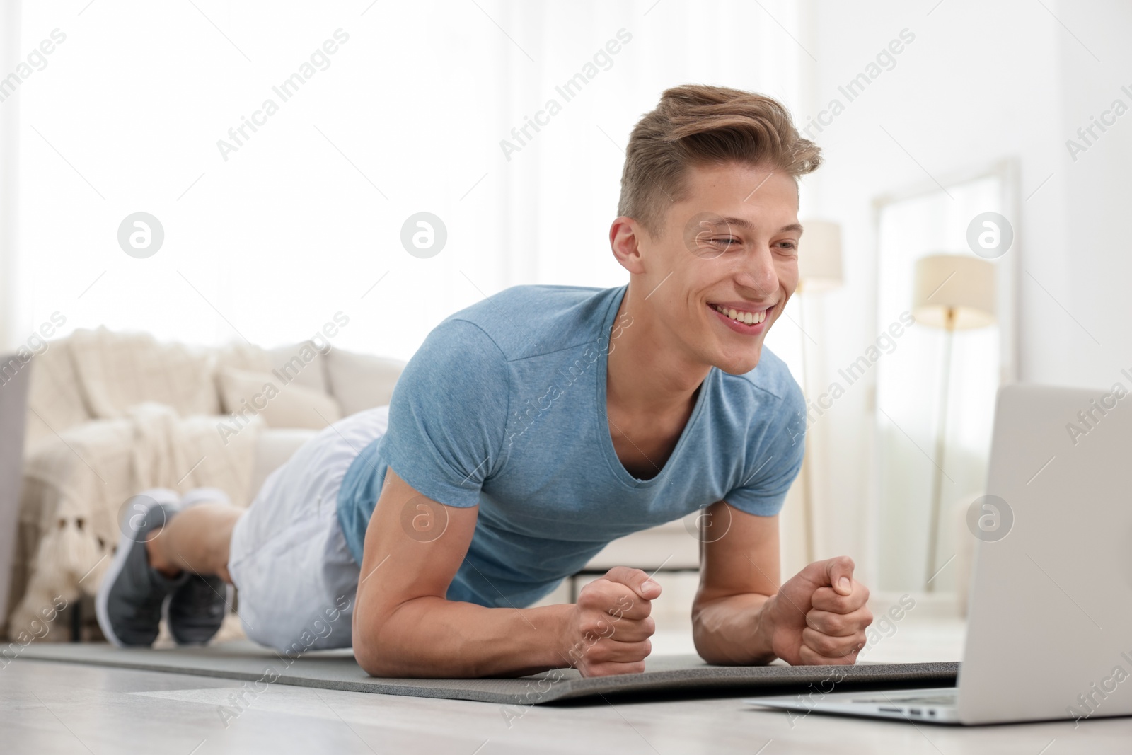 Man doing plank exercise during online class with coach at home. Sport and healthy lifestyle Photo of Man doing plank exercise during online class with coach at home. Sport and healthy lifestyle