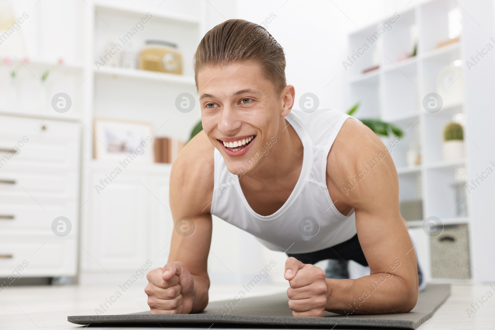 Man doing plank exercise at home. Sport and healthy lifestyle Photo of Man doing plank exercise at home. Sport and healthy lifestyle
