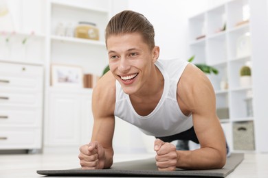 Photo of Man doing plank exercise at home. Sport and healthy lifestyle