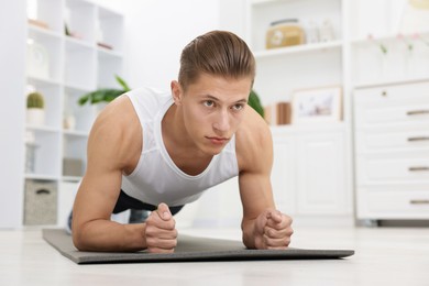 Photo of Man doing plank exercise at home. Sport and healthy lifestyle