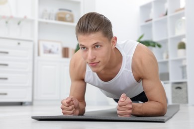 Photo of Man doing plank exercise at home. Sport and healthy lifestyle
