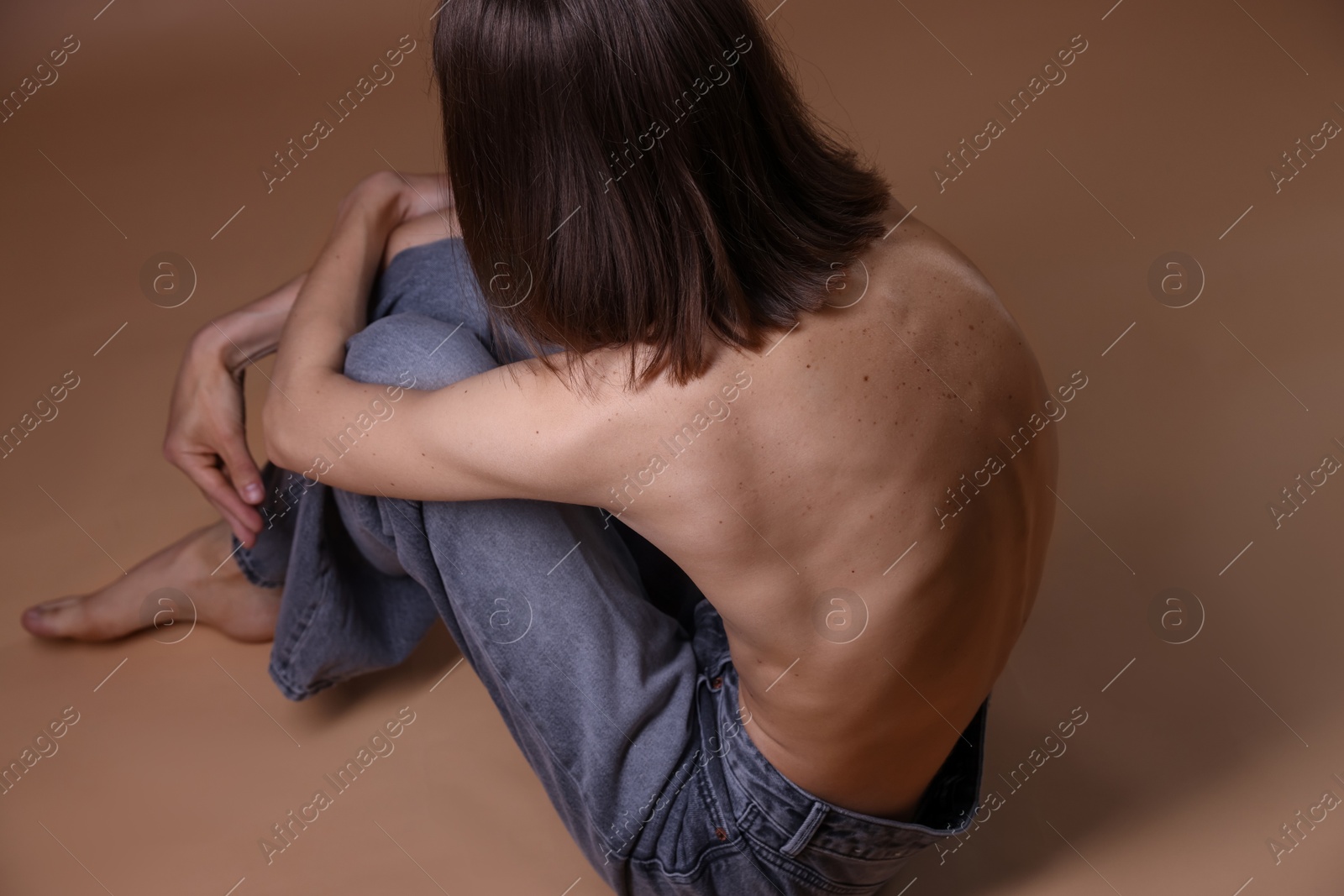 Woman suffering from anorexia on dark beige background, above view Photo of Woman suffering from anorexia on dark beige background, above view