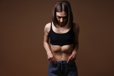 Photo of Woman suffering from anorexia on brown background