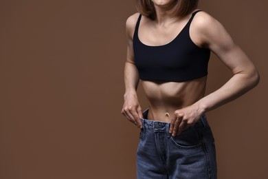 Photo of Woman suffering from anorexia on brown background, closeup. Space for text