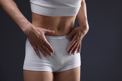 Photo of Woman suffering from anorexia on grey background, closeup. Space for text