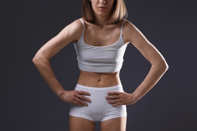 Photo of Woman suffering from anorexia on grey background, closeup