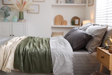 Photo of Comfortable bed with soft linens and blankets in room. Home textile