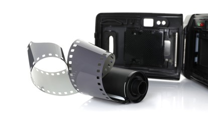 Photo of Roll of photographic film and photo camera isolated on white
