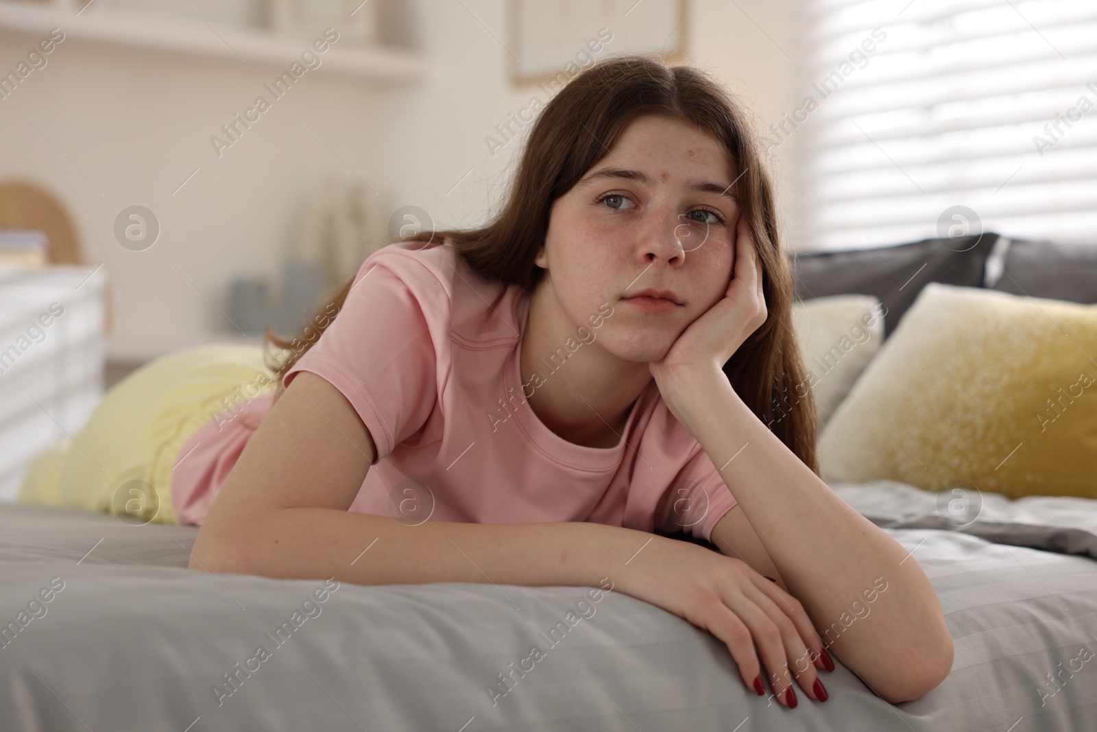 Upset teenage girl on bed at home Photo of Upset teenage girl on bed at home