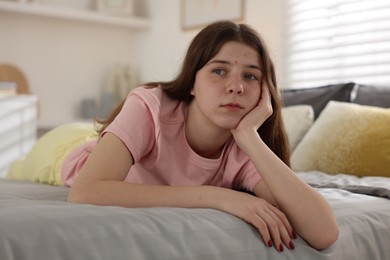Photo of Upset teenage girl on bed at home