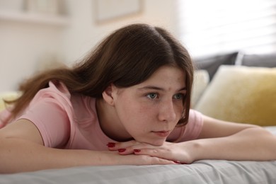 Photo of Depressed teenage girl on bed at home