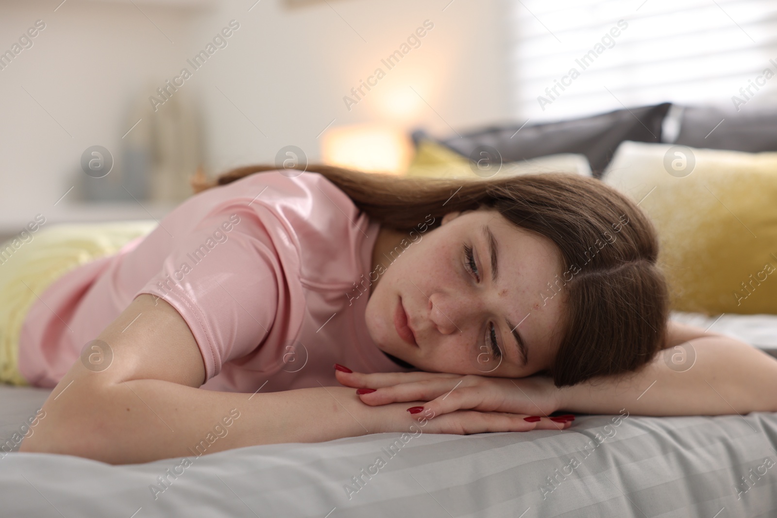 Depressed teenage girl on bed at home Photo of Depressed teenage girl on bed at home