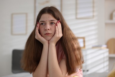 Photo of Upset teenage girl on bed at home