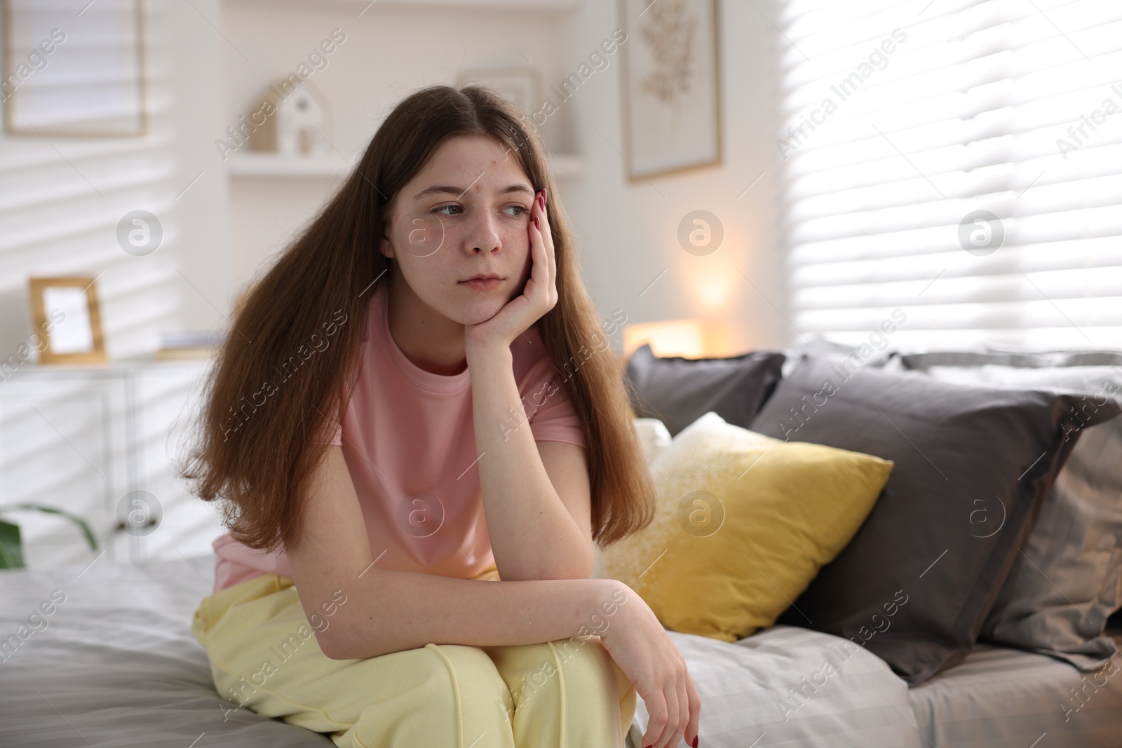 Upset teenage girl on bed at home Photo of Upset teenage girl on bed at home