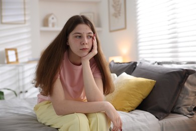 Photo of Upset teenage girl on bed at home