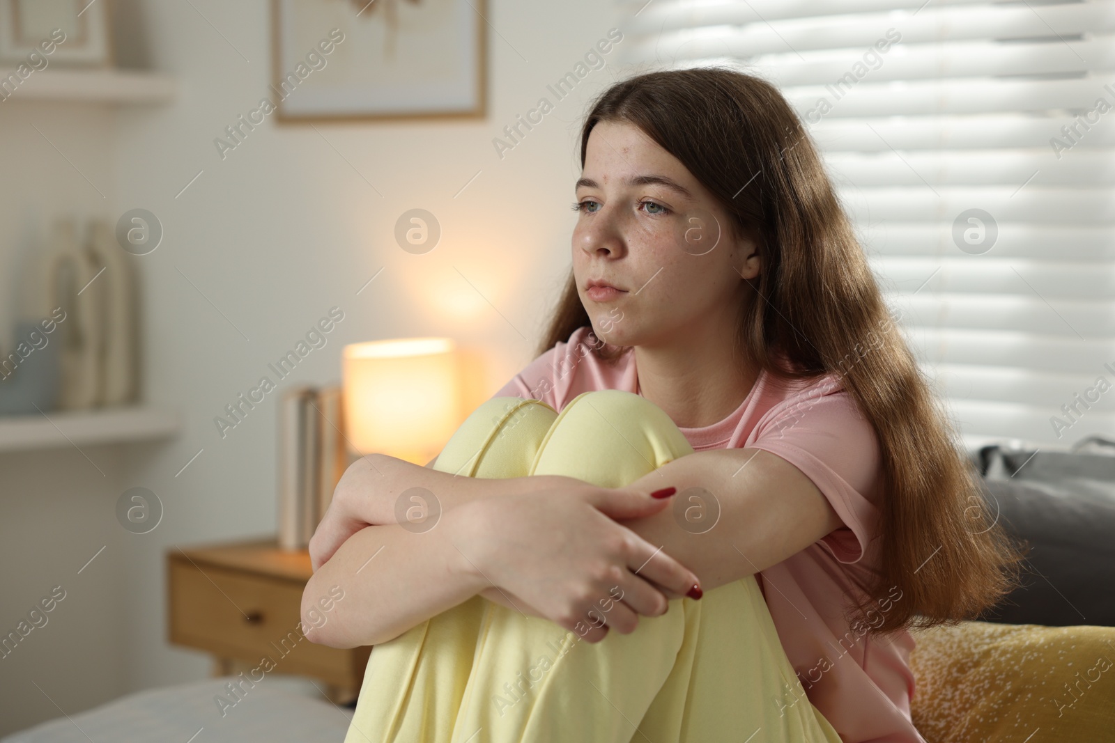 Depressed teenage girl on bed at home. Space for text Photo of Depressed teenage girl on bed at home. Space for text