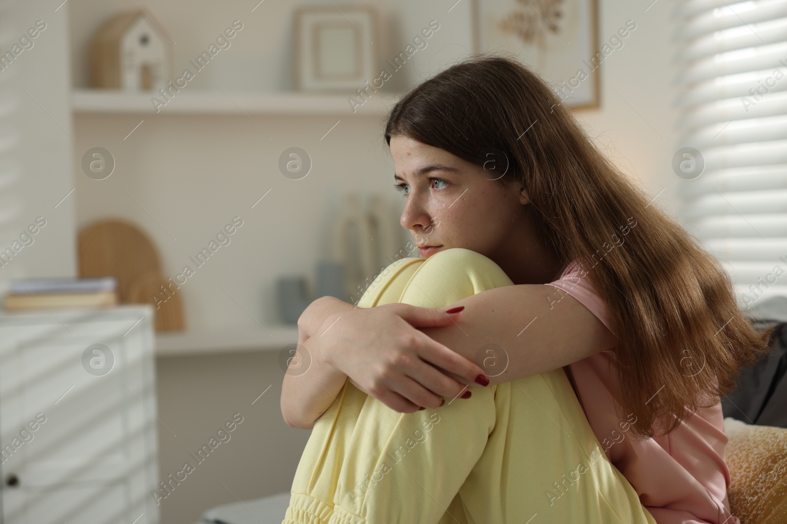 Depressed teenage girl on bed at home. Space for text Photo of Depressed teenage girl on bed at home. Space for text