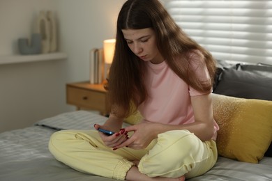 Photo of Upset teenage girl on bed at home