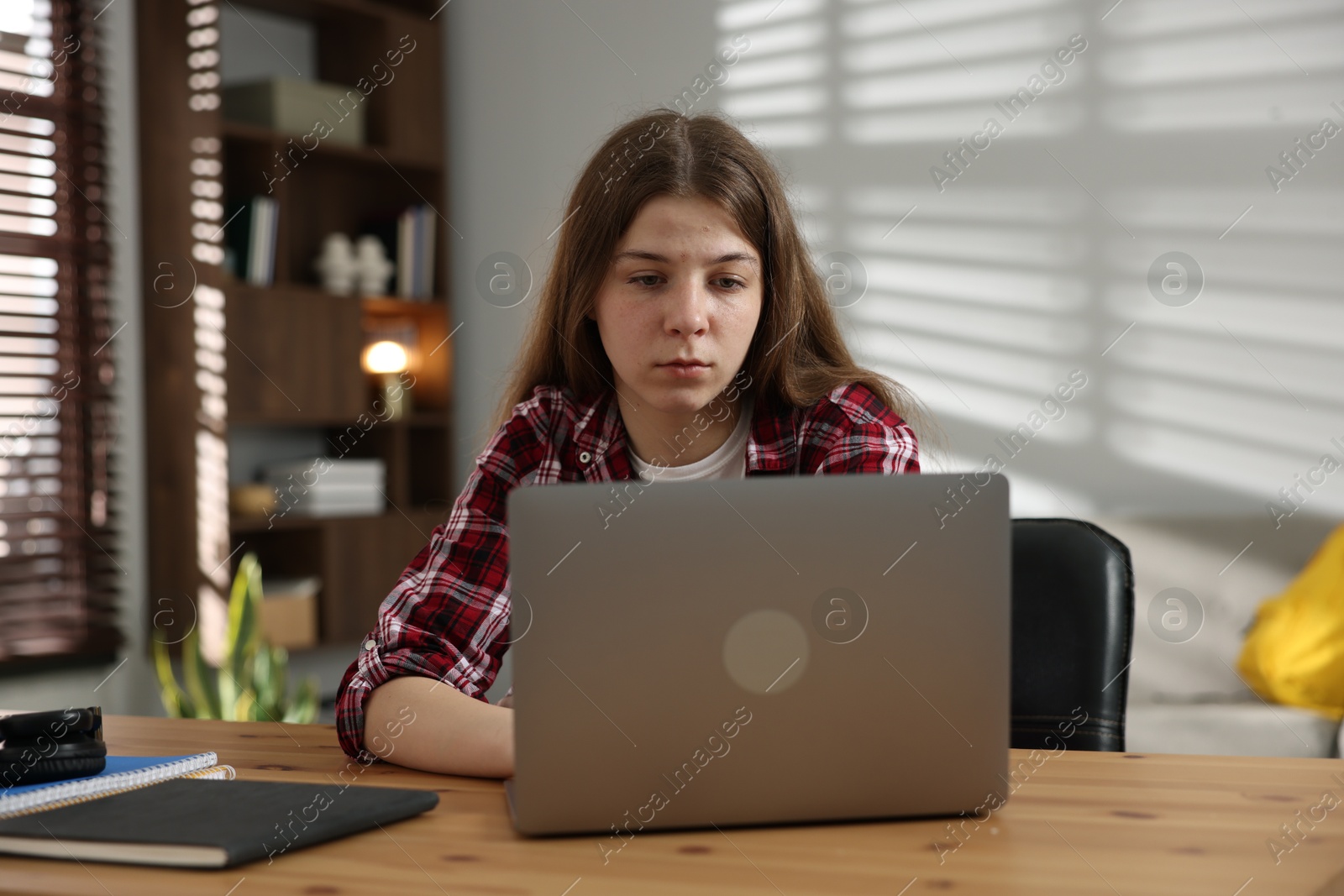 Stressed teenage girl studying at desk indoors Photo of Stressed teenage girl studying at desk indoors